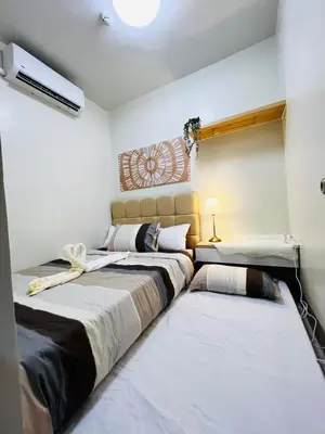 two beds in a room with white walls at MOA GRAND STAY Suite08 Newly Turn-over Only! in Manila