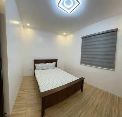 a bedroom with a bed in a room with a window at 4 Bedroom House for 5-6 guests in Manila