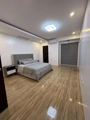 a bedroom with a bed and a wooden floor at 4 Bedroom House for 5-6 guests in Manila