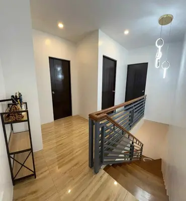 a staircase in a room with white walls and wooden floors at 4 Bedroom House for 5-6 guests in Manila