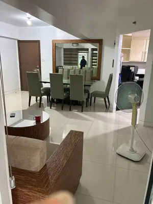 a living room with a table and green chairs at Parkside Villas G NEWPORT Philippines in Manila