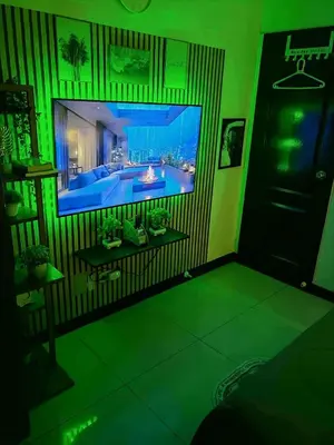 a living room with a large tv and green lighting at Staycation at Brgy Cupang in Manila