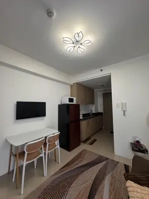a living room with a table and a kitchen at The Chill Lane- Shore Residences in Manila