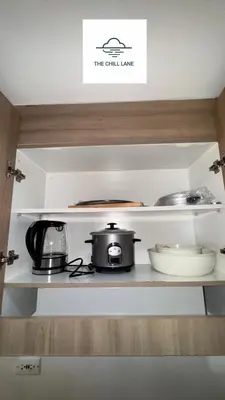 a kitchen shelf with pots and pans on it at The Chill Lane- Shore Residences in Manila