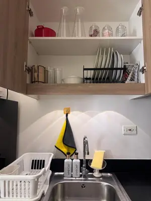 a kitchen sink with a dish drying rack above it at The Chill Lane- Shore Residences in Manila