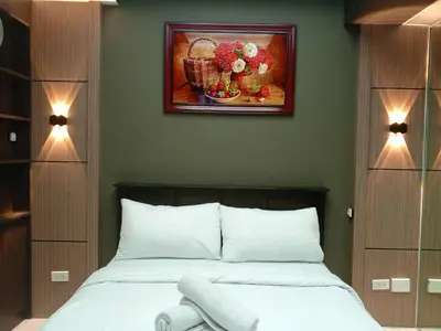 a bedroom with a bed and a painting on the wall at Cozy Manila Condo Retreat with Shared Pool in Manila