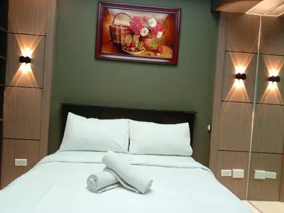 a bedroom with a white bed with a picture on the wall at Cozy Manila Condo Retreat with Shared Pool in Manila