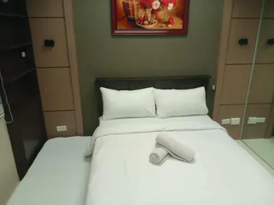 a bed with a towel on top of it at Cozy Manila Condo Retreat with Shared Pool in Manila