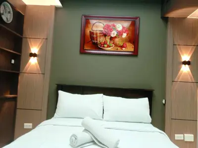 a bedroom with a bed and a painting on the wall at Cozy Manila Condo Retreat with Shared Pool in Manila