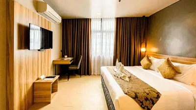 a hotel room with a large bed and a desk at Madison 101 Hotel + Tower in Manila