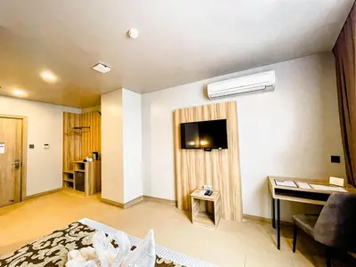 a hotel room with a bed and a desk and a television at Madison 101 Hotel + Tower in Manila