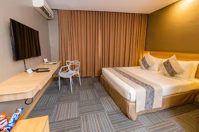 a hotel room with a bed and a desk at Madison 101 Hotel + Tower in Manila