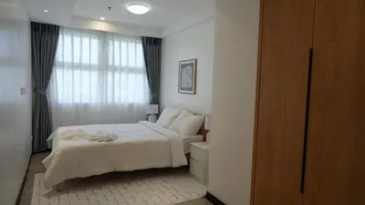 a bedroom with a white bed and a window at Coastal Luxury Residences in Manila