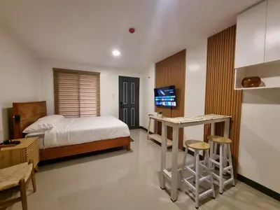 a bedroom with a bed and a desk and a tv at Flat 35, Unit E in Manila