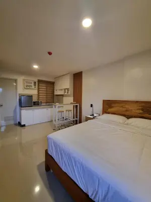 a bedroom with a large bed and a kitchen at Flat 35, Unit E in Manila