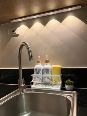 a kitchen sink with two bottles of laundry detergents at Cami Haus at Fame Residences in Manila