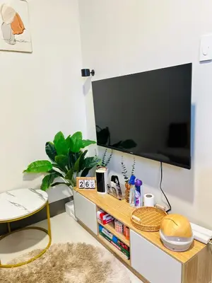 a living room with a flat screen tv on a tv stand at Cami Haus at Fame Residences in Manila