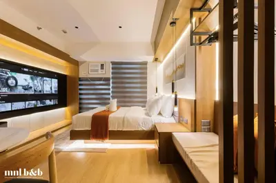 a bedroom with a bed and a flat screen tv at Near Venice Mall! Hotel 1BR Unit in Viceroy Residences in Manila