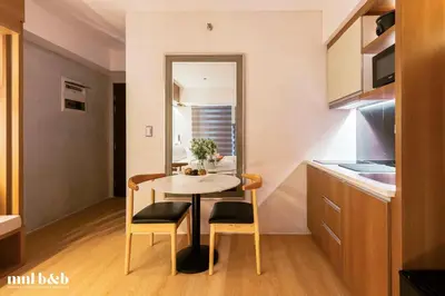 a small kitchen with a table and chairs in a room at Near Venice Mall! Hotel 1BR Unit in Viceroy Residences in Manila