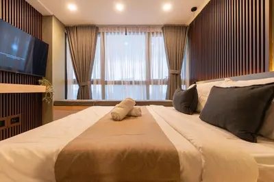a large bed in a room with a large window at Amazing View - Cozy 1BR at One Eastwood with Washer High Speed Wi-Fi in Manila