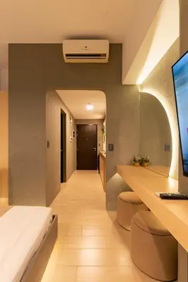 a room with a bed and a desk with a computer at Amazing View - Cozy 1BR at One Eastwood with Washer High Speed Wi-Fi in Manila