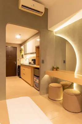 a kitchen with a counter and stools in a room at Amazing View - Cozy 1BR at One Eastwood with Washer High Speed Wi-Fi in Manila