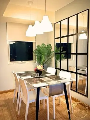 a dining room with a table and white chairs at Azure Staycation by Casa Tremora Deluxe in Manila
