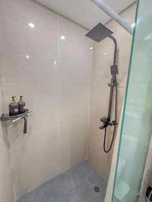 a shower stall with two figurines in a bathroom at nJoy! Elegant Peach Heaven at Venice Grand Canal in Manila