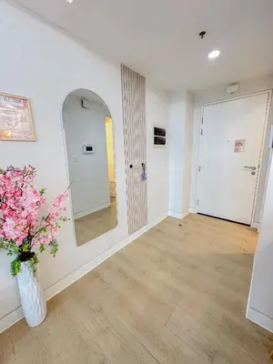 a hallway with a mirror and a vase with flowers at nJoy! Elegant Peach Heaven at Venice Grand Canal in Manila