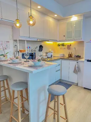 a kitchen with white cabinets and bar stools at nJoy! Elegant Peach Heaven at Venice Grand Canal in Manila