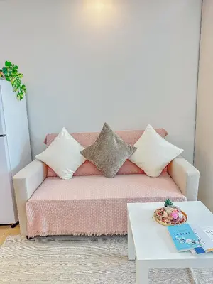 a living room with a couch with pillows and a table at nJoy! Elegant Peach Heaven at Venice Grand Canal in Manila