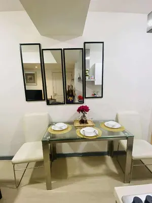 a dining room table with two chairs and mirrors at Azure Urban Condomiun Near Airport in Manila