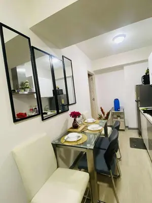 a dining room with a table and chairs in a room at Azure Urban Condomiun Near Airport in Manila