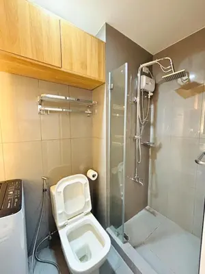 a bathroom with a toilet and a glass shower at Luxurious Room in Bel Air Makati - Air Residences in Manila
