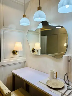 a bathroom with a table with a mirror and lights at Luxurious Room in Bel Air Makati - Air Residences in Manila