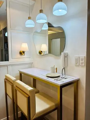 a bathroom with a vanity with two chairs and a mirror at Luxurious Room in Bel Air Makati - Air Residences in Manila