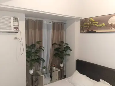 a bedroom with a bed and two potted plants at Staycation in Brgy Cupang in Manila