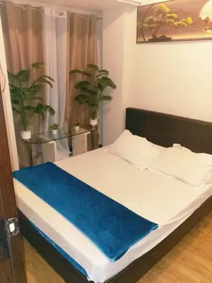 a bedroom with a bed with a blue blanket on it at Staycation in Brgy Cupang in Manila