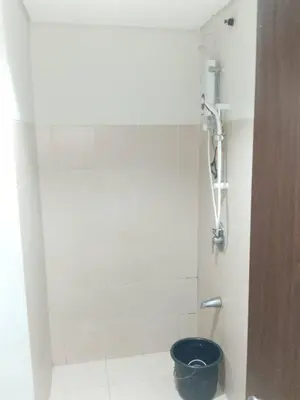 a bathroom with a toilet with a black bucket at Staycation in Brgy Cupang in Manila
