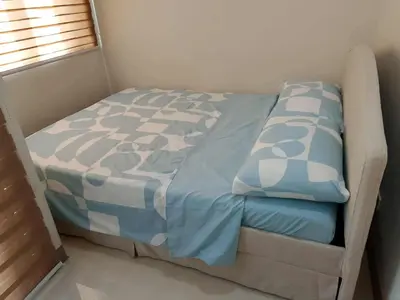 a bed with blue and white sheets in a room at Marhulz Two Bedroom Staycation at S Residences in Manila