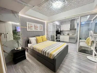 a small bedroom with a bed and a kitchen at Azure Staycation by Cm in Manila