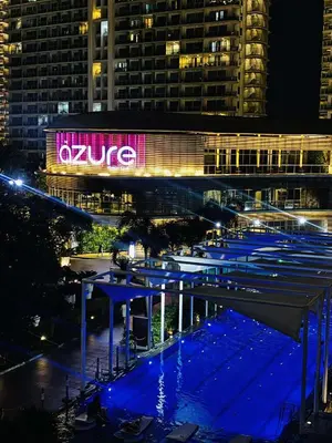 a building with a lit up sign at night at Azure Staycation by Cm in Manila