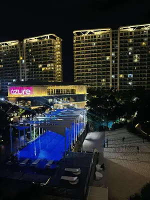 a view of a building with a pool at night at Azure Staycation by Cm in Manila