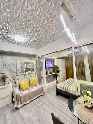 a bedroom with a bed and a couch and a table at Azure Staycation by Cm in Manila