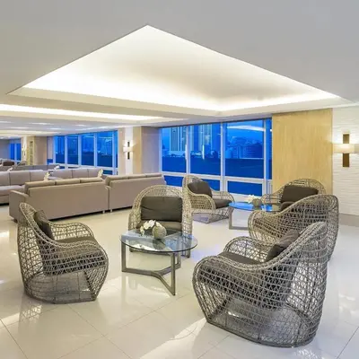 a lobby with wicker chairs and tables in a building at Smdc Breeze Residences-The Metro Breeze-Staycation in Manila