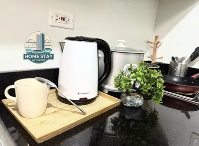 a coffeemaker sitting on a kitchen counter with two cups at SHORE 2 Residences MALL OF ASIA, NAIA, PICC in Manila
