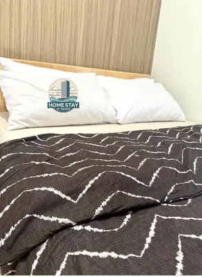 a bed with a black and white blanket on it at SHORE 2 Residences MALL OF ASIA, NAIA, PICC in Manila