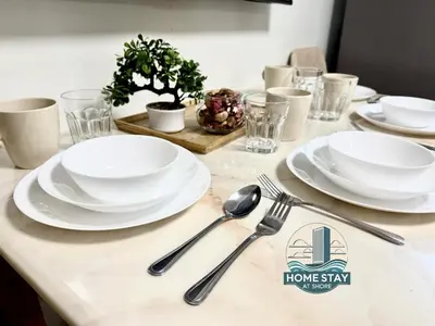 a table with white plates and utensils on it at SHORE 2 Residences MALL OF ASIA, NAIA, PICC in Manila