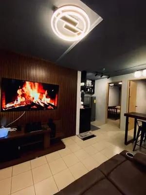 a living room with a flat screen tv on a wall at Staycation in Brgy Buli in Manila