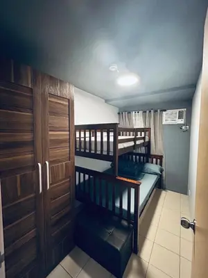 two bunk beds in a small room with a door at Staycation in Brgy Buli in Manila